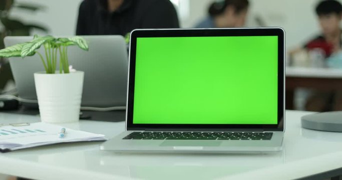 Green laptop computer screen set in front of workgroup