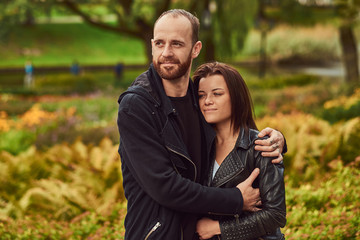 Happy modern couple in a park. Enjoying their love and nature.