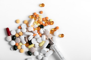 Pills and and syringe on blue background