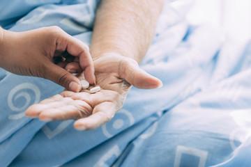 Nurse with patient. Routine health check and giving medication. Female nurse with senior chinese woman.