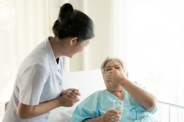 Obraz premium Pielęgniarka z pacjentem. Rutynowa kontrola stanu zdrowia i podawanie leków. Żeńska pielęgniarka z starszą Chinką.