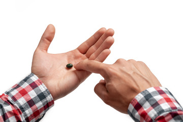 pill in man's hand on white background