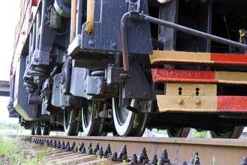 The wheels of the diesel locomotive on the rails. Railway transport.