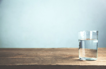 Un verre d& 39 eau sur une table en bois.