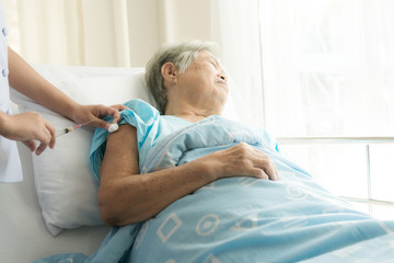 Obraz premium Nurse with patient. Routine health check and doing medical injection. Female nurse with senior chinese woman.