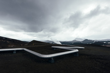 Iceland landscape with pipes in mountains. Geothermal energy in operations