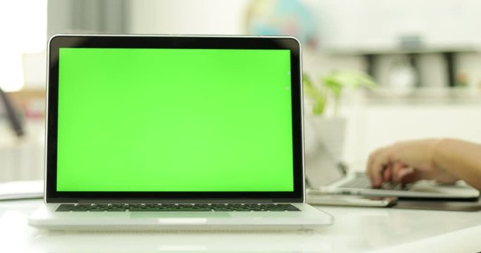 Green laptop computer screen set in front of workgroup