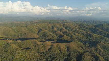 Fototapeta premium Aerial view of mountains covered forest, trees. Tropical landscape: mountains, sky with clouds. on the island of Luzon, Philippines. Mountain province, Cordillera region.