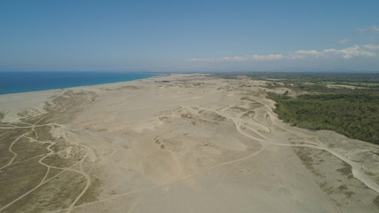 Aerial view of beautiful lonely beach and Paoay sand dune. Philippines, Luzon. Sand dunes near to the sea with sky. Ilocos Norte.