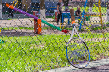 Tennis racket is near the grid