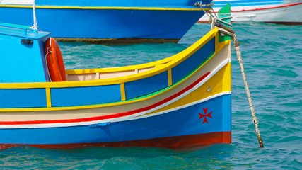 Fototapeta na wymiar Marsachlokk - MALTA: Colorful Maltese boats in the harbor in Malta in the fishing village of Marsachlokk.