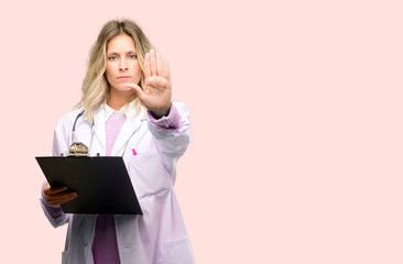 Young doctor woman, medical professional annoyed with bad attitude making stop sign with hand,...