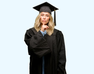 Young graduate woman with index finger on lips, ask to be quiet. Silence and secret concept