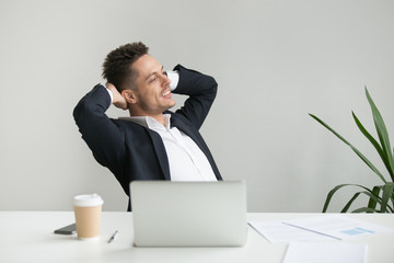 Satisfied office worker leaning back in chair happy after finishing work business project, reading...
