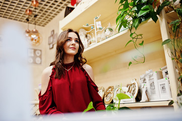 Brunette girl in red buy flowers at flower store.