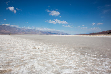 Badwater in den Badlands der USA , eine weite weisse Salzebene mit intensiv blauem Himmel
