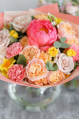Bouquet of beautiful flowers on gray table. Floristry concept. Spring colors. the work of the florist at a flower shop. Vertical photo