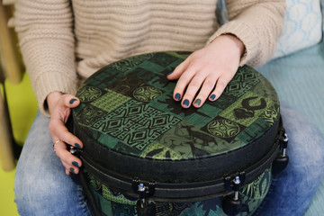 Teacher plays jenga drum in a montessori music therapy classroom,  hands close up