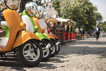 three mopeds painted in red green yellow colors