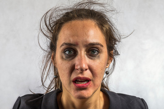 Desperate woman crying disheveled with pale eyes with makeup clouded perhaps by depression or gender violence. Image rich in detail