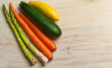 Top view of freshly picked, two asparagus, carrots and a zucchini and yellow squash 