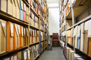 Carton boxes for paper documents, drawings and records standing on steel shelves in archive room