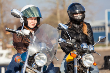 Portrait of two European pretty female bikers with classic and street style bikes