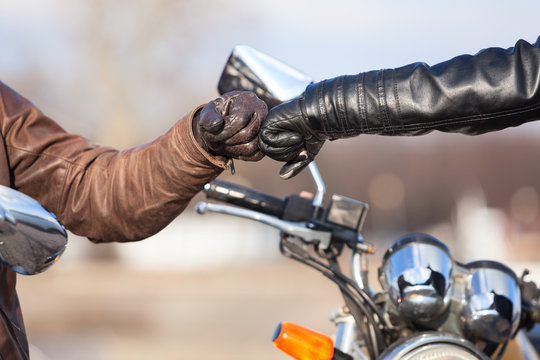 Fototapeta Close up of bikers hands in leather gloves with repay salutation