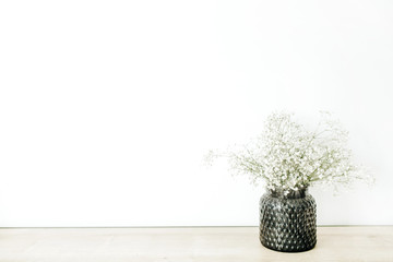 White gypsophila flowers bouquet in flowerpot at white background. Minimal floral concept.