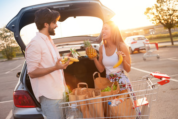 Happy couple having fun while bought at a supermarket