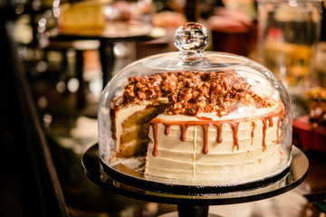 Caramel cake under glass bell dome. Cake stand, dessert buffet, storage