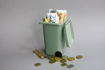 Euro money: closeup of banknotes and coins in the garbage can. 