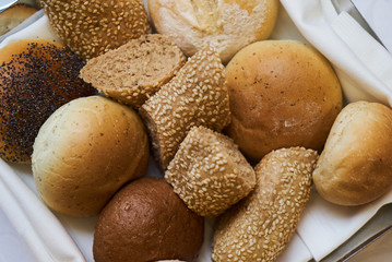 Variety of sliced bread in basket, close-up. A lot on mixed bun, top view 