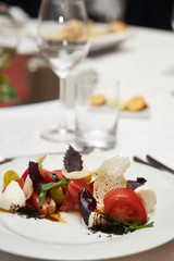 Vegetarian food with marinated tomatoes, arugula, mozzarella cheese, balsamic jelly, olive oil. Delicious healthy food concept, close-up