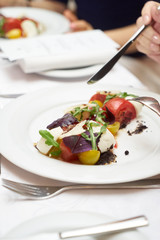 Vegetarian food with marinated tomatoes, arugula, mozzarella cheese, balsamic jelly, olive oil. Delicious healthy food concept, close-up