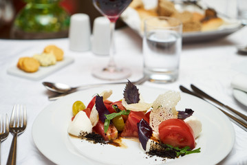 Vegetarian food with marinated tomatoes, arugula, mozzarella cheese, balsamic jelly, olive oil. Delicious healthy food concept, close-up