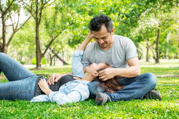 Naklejka na ściany i meble Romantic couple in park. Chinese asian man and woman in park relaxing and loving each other.