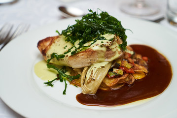 People eating roasted organic chicken dish with tarragon, mustard sauce, rosemary, potatoes tian...
