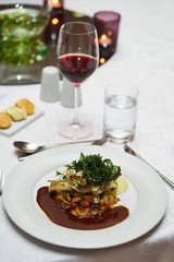 People eating roasted organic chicken dish with tarragon, mustard sauce, rosemary, potatoes tian and confit fennel, close-up. Delicious healthy food dinner on serving table concept
