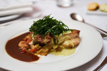 People eating roasted organic chicken dish with tarragon, mustard sauce, rosemary, potatoes tian and confit fennel, close-up. Delicious healthy food dinner on serving table concept