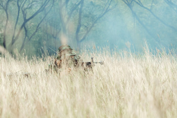 Soldier hiding in bushes ready to shoot. Ambush his ememy, ready his assault rifle. Hiding below...