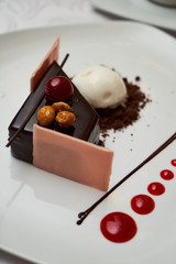 Black forest Cake with cherry, vanilla ice-cream, chocolate and cup of hot tea on table. Delicious sweet dessert breakfast on table background, close-up