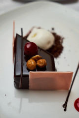 Black forest Cake with cherry, vanilla ice-cream, chocolate and cup of hot tea on table. Delicious sweet dessert breakfast on table background, close-up