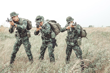 Fototapeta premium Soldier ready his weapon. Standing up holding their assault rifle. Portrait full body shot. Digital green camo.