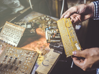 close up hand repairing board circuit chip in workshop