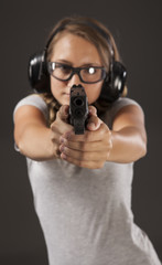 Girl learning to shoot a gun.