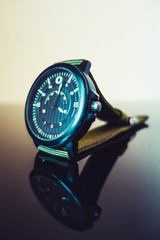 close-up of a watch standing on a reflective surface