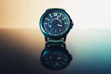 close-up of a watch standing on a reflective surface