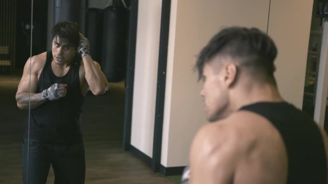 Young man shadowboxing in front of mirror. Slow motion