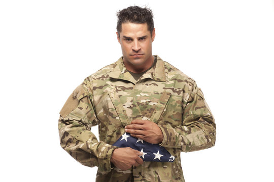 Soldier holding folded American flag